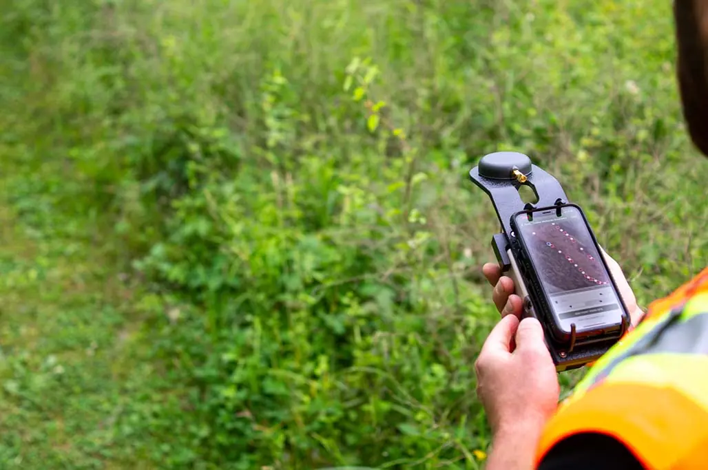 Environmental scientist using mobile device with GPS receiver for wetland data collection in the field