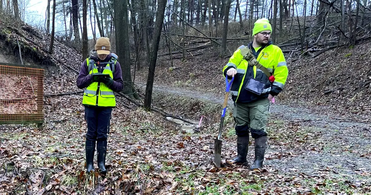 Environmental scientist conducting wetland field assessment using Ecobot Collector mobile app with GPS receiver for accurate geospatial data collection