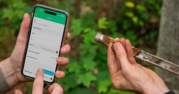 Field biologist conducting wetland delineation survey using Ecobot Collector mobile app